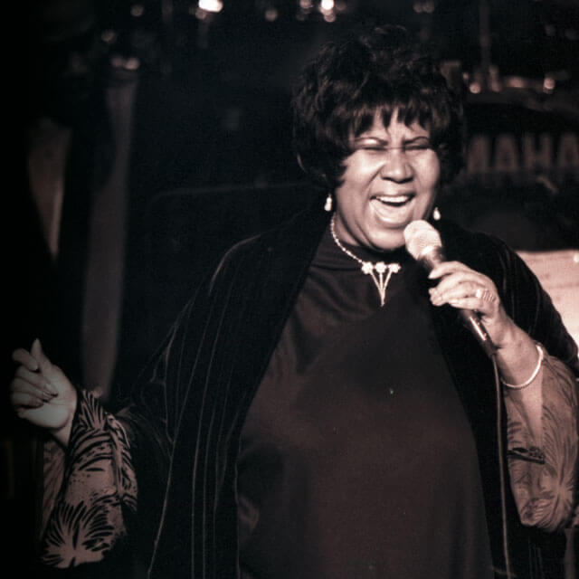 Aretha Franklin singing onstage.