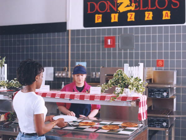 A student grabs pizza at Donzello's.