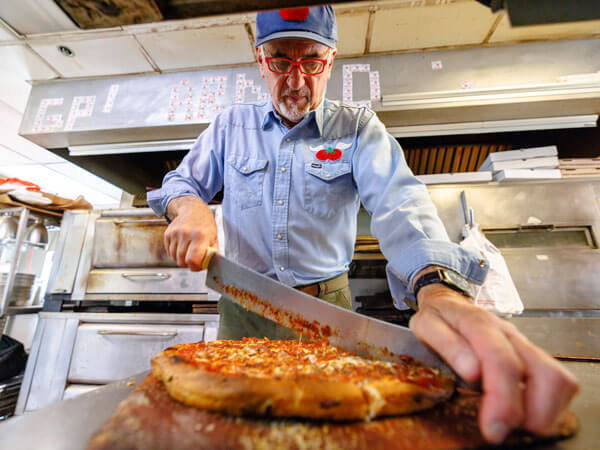 Ralph slices a pizza.