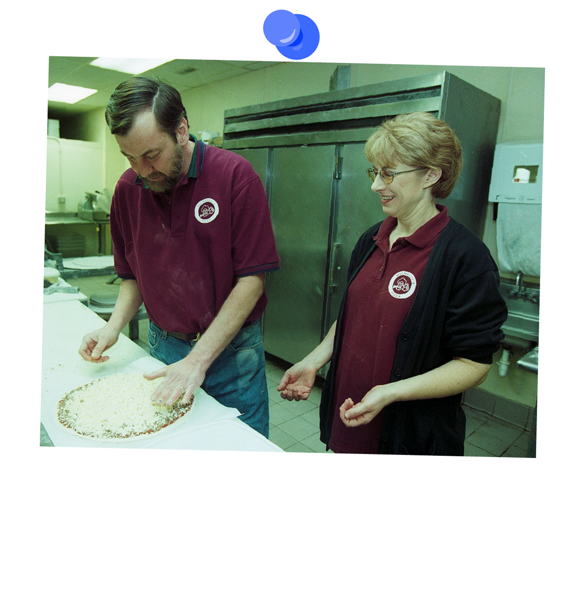 The owners of Micheleo's prep pizzas with toppings.