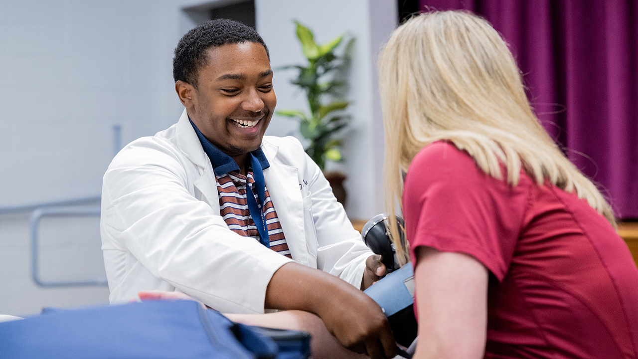 Student taking blood pressure of patient