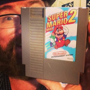In this photo he is holding Super Mario 2. His face is in a different position that others.