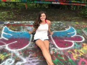Marissa sitting on graffiti ground
